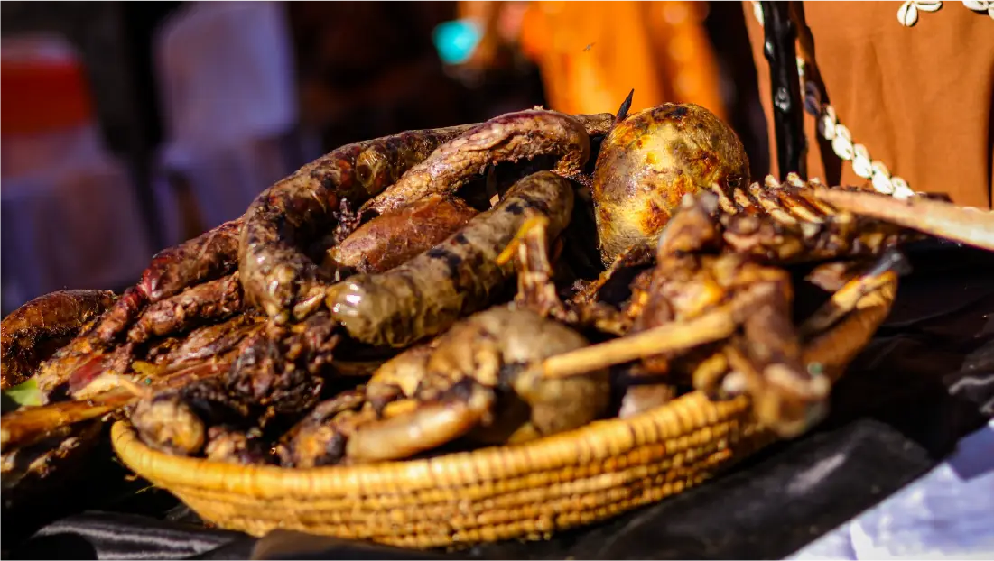 Nyama Choma (roasted goat meat) served fresh from the grill, a popular Kenyan and Tanzanian barbecue dish traditionally enjoyed with kachumbari, ugali, and friends during social gatherings.